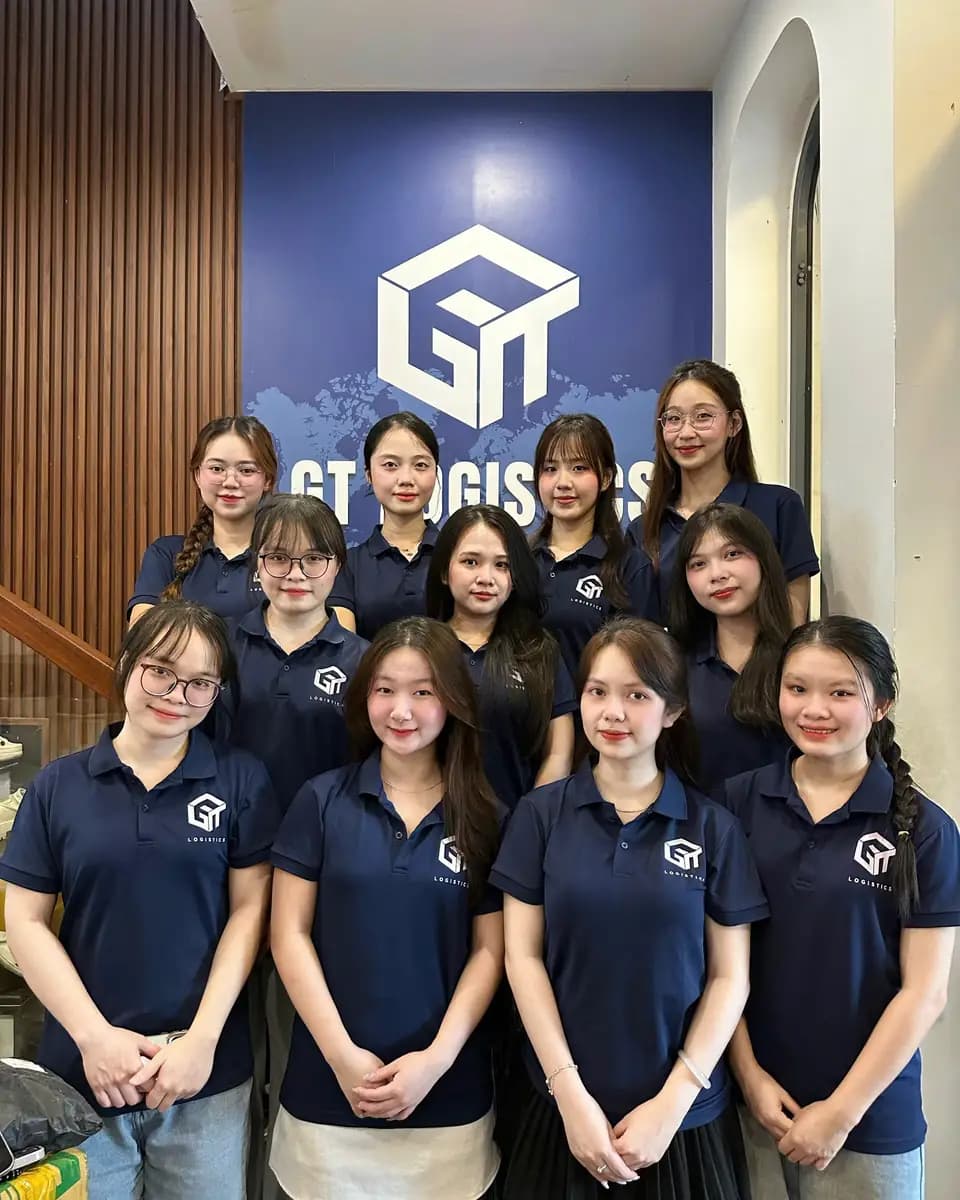 Đội ngũ GT Logistics trước bức tường logo công ty