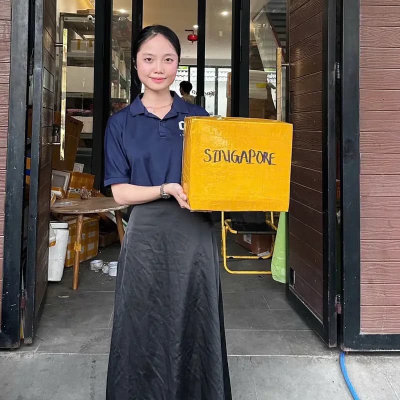 Nhân viên cầm thùng hàng gửi đi Singapore